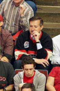 Ricketts watches the Hawks win wearing a jersey over his business shirt.
